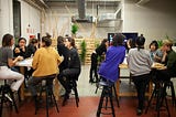 grupo de mujeres sentadas en bancos en un espacio de cowork reflexionando.