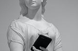 A marble statue of a woman holding a smartphone.