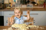 baby eating a plate of spaghetti
