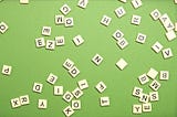 Scrabble letters thrown onto a mid-green background.