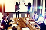A dynamic and engaging conference room scene focused on collaboration and innovation through the use of whiteboards. The room is filled with a diverse group of professionals, actively participating in a brainstorming session.