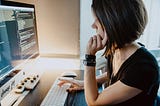 Woman sitting in front of a computer coding.