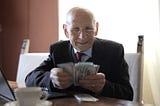 Old banker in suit counting money notes