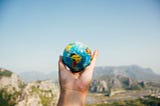 Person holding a globe in their hand