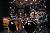 An extremely elaborate drum kit sits on stage after a concert