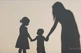 Silhouettes of a woman holding hands with two children, suggesting family, inherited wounds, protection, and grace.