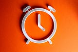While clock with no numbers on a bright orange background