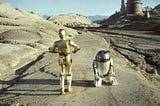 C3PO and R2D2 from Star Wars walking in a desert