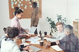 Group of People Sitting Indoors and Brainstorming