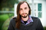 Spencer Creaghan, composer, sitting in front of a window