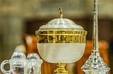 fancy communion cups on a church altar in gold, silver, and crystal