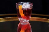 A Ruby Red Negroni Cocktail with an Orange Twist in an Elegant Crystal Glass