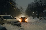 Car on highway in snow storm with lights