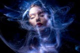 Beautiful woman’s face surrounded with swirls of light against a dark sky