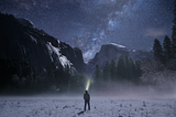 Photo from Unsplash: Man in snowy mountain pass in night, looking at sky with a headlamp — a metaphore for clarity.