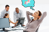 A woman relaxes at her desk while her colleagues work in the background.