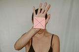 Woman showing a paper with a big X on it.