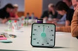 A bunch of poeople sitting aroudn a table with a timer in focus about to tick down.