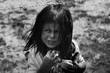 Photo of anguished child behind a barbed wire fence in El Salvador