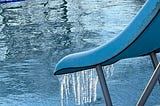 a view of parliament hill lido with icicles hanging from the slide