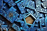 An abstract composition featuring geometric shapes in varying shades of blue and brown, resembling an intricate puzzle piece.