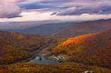 lake in a valley between the mountains in autumn