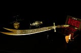 Zulfiqar, the most powerful sword in history, resting on a stand. The double-pointed blade is adorned with intricate Arabic inscriptions.