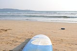 A surfboard on a sandy beach.