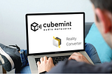 Man sitting with laptop on lap. The screen shows the logos of Cubemint and Reality Converter.