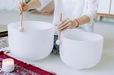 Person playing crystal singing bowls for sound therapy and healing