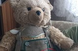 shows photo of champagne teddy bear wit a Bavarian Lederhosen und elegant red shoes! he is Hardy the teddy my parents used.