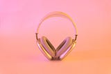 Headphones standing in front of a pink background.