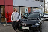 Sophie stood next to her Vauxhall Corsa-E outside the Vauxhall dealership.