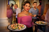 Image by ZigarrenZone on Pixabay of a Cuban woman serving food to male tourists in Cuba