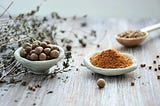 medicinal herbs in small bowls and dried leaves on a wooden table