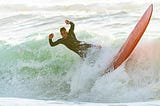 Image of a man falling off a surf board