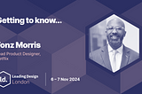 The image features the following text content: **Headline**: “Getting to know…” **Main content**: “Fonz Morris Lead Product Designer, Netflix” **Event details**: “Leading Design London 6–7 Nov 2024” The design includes a photo of Fonz Morris on the right side, with a geometric pattern in shades of dark blue and purple serving as the background. The text is written in white and light pink, with the Leading Design London logo on the lower left side.