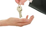 man-handing-house-keys-new-owner-isolated-white-background — Un Swede