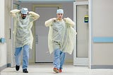 Two doctors put on PPE to care for patient