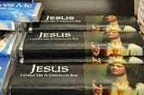 A stack of chocolate bars called “Jesus I Could Use A Chocolate Bar” with an image of Jesus.