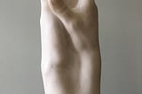 Sculpture in white marble, two right hands joined like a spire reaching towards the sky