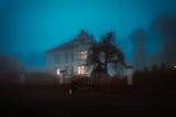 Mansion in the dark, with lit interior.