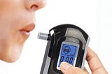 A person about to blow into an alcohol tester