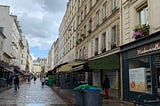 A rainy day on the cobblestone streets of rue Cler in Paris, France