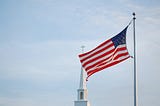 American flag with church steeple in backgroung