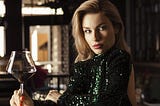 Attractive woman staring seductively while holding a glass of wine.