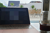 Macbook Air on a glass table in a rooftop cafe in Asia