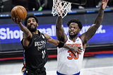 Brooklyn Nets guard Kyrie Irving drives for a layup past Knicks forward Julius Randle