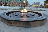 The Canadian Centennial Flame granite monument on Parliament Hill. It’s an ongoing fire using bio-gas, first lit in 1967, that doesn’t extinguish in the winter. The year that the province or territory joined Canada is carved into the granite in front of the shield. Photo Credit — Roxanne Joseph