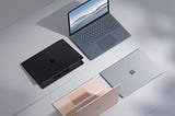 Four Surface Laptop 4s. One rose gold, one black, one silver and another one that is open.